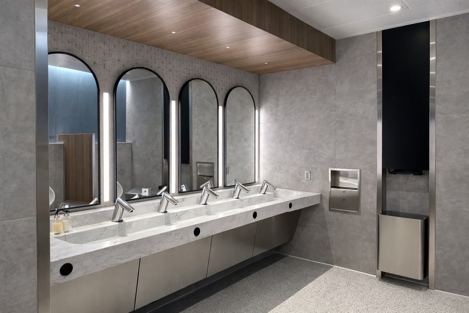 Commercial washroom basin bank illustrating coordinated automatic dispensing stations