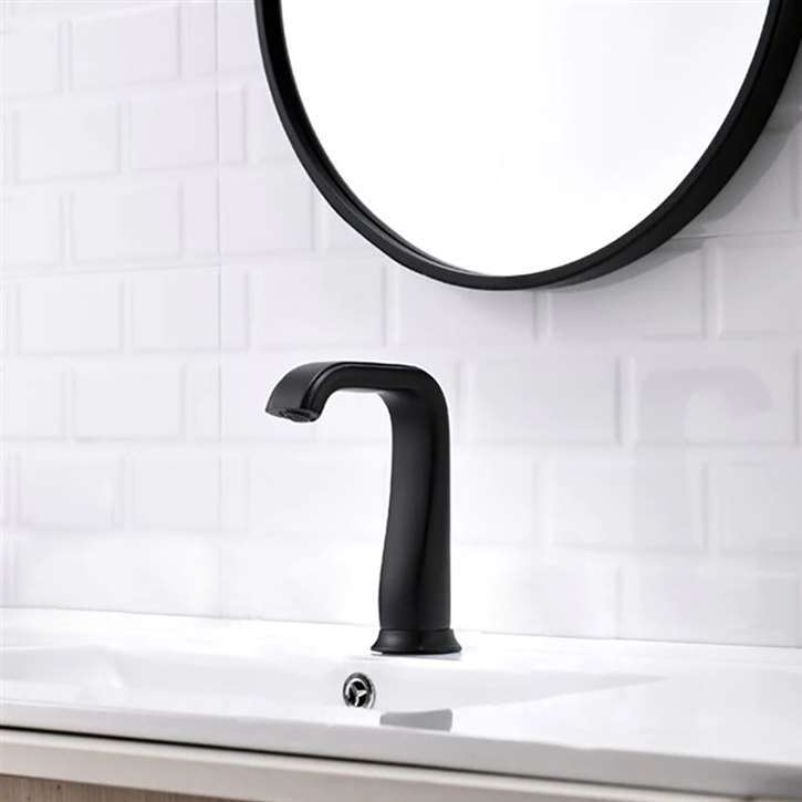 Matte black touchless faucet above a white basin with a circular mirror
